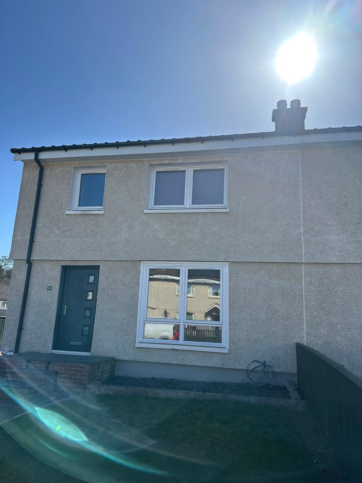 The same front with a new white fascia and soffit, plus a new black gutter and downpipe
