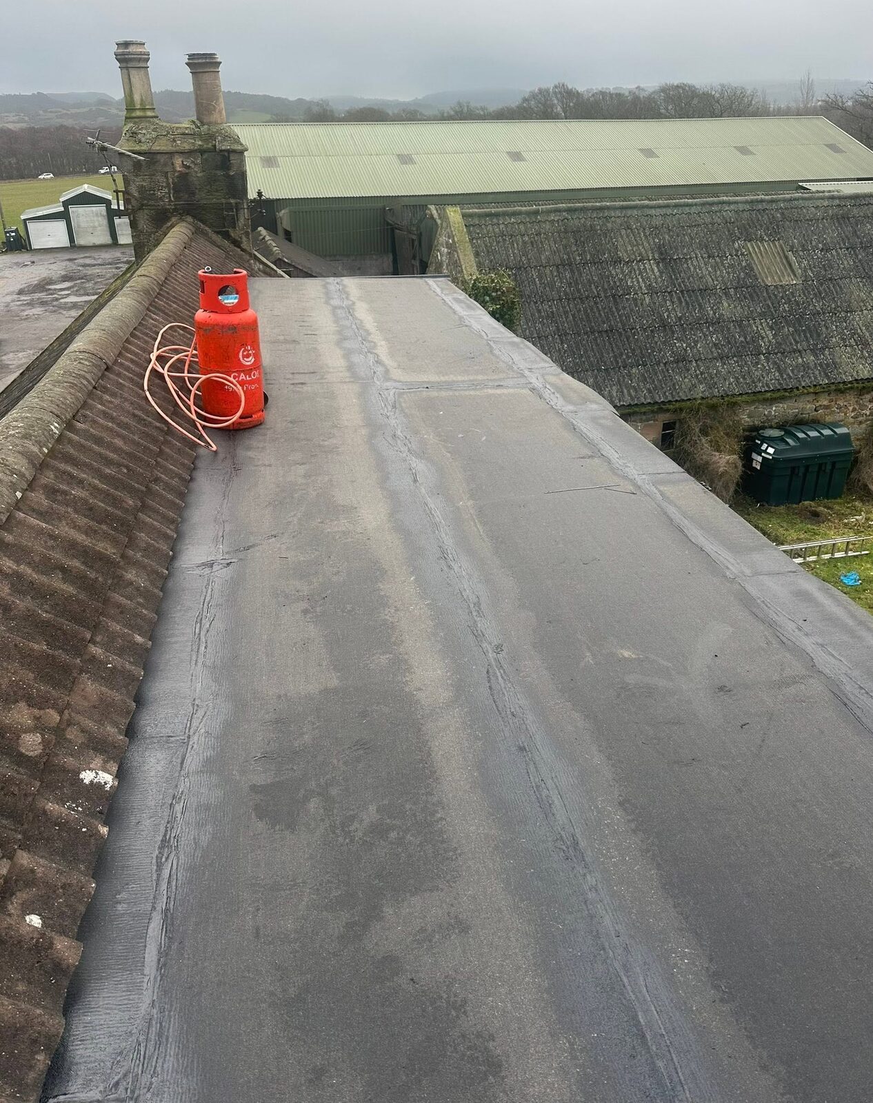The same flat roof with black torch-on underlay laid and lapped