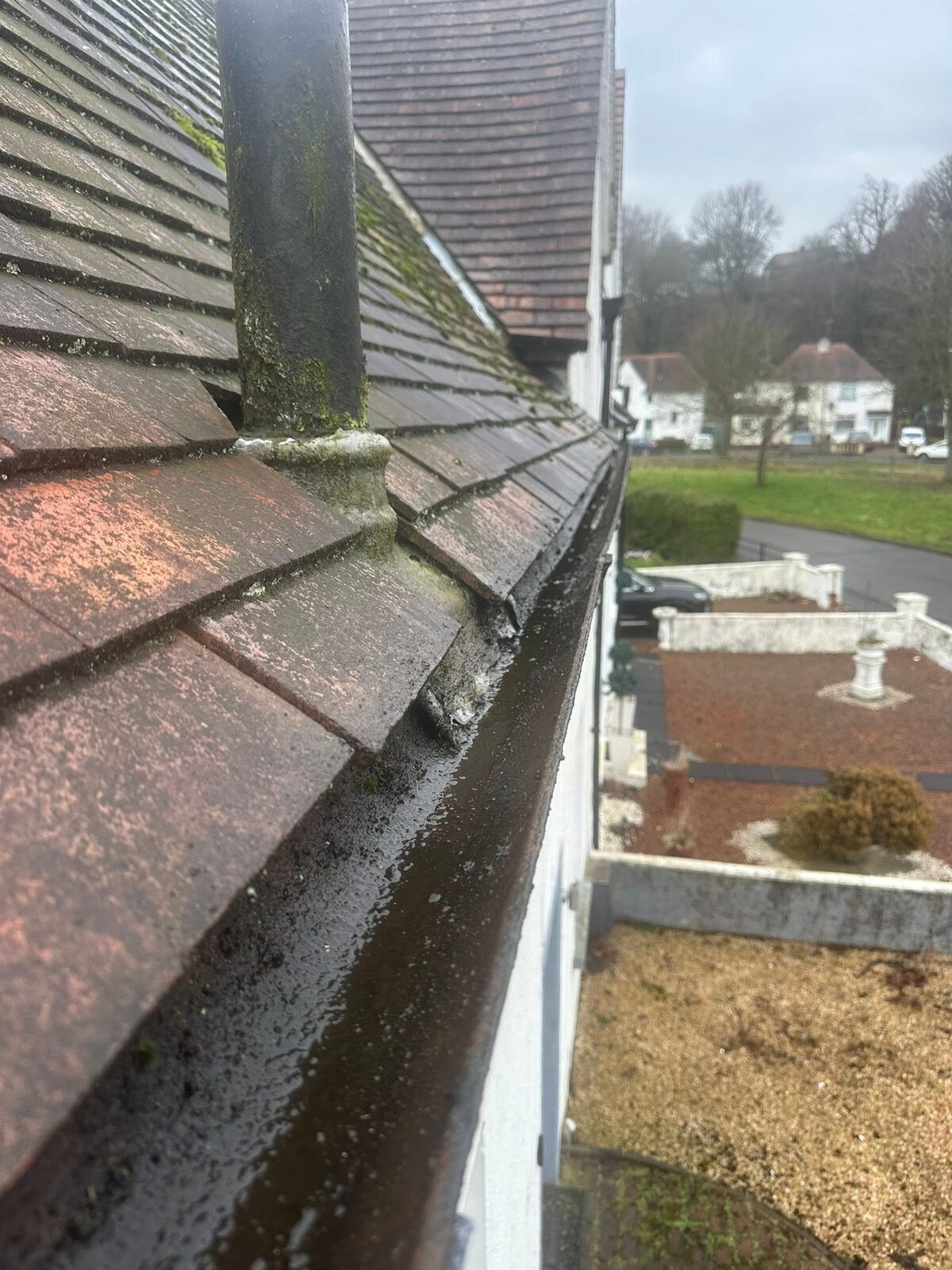 The gutter cleared and rinsed beside red concrete tiles
