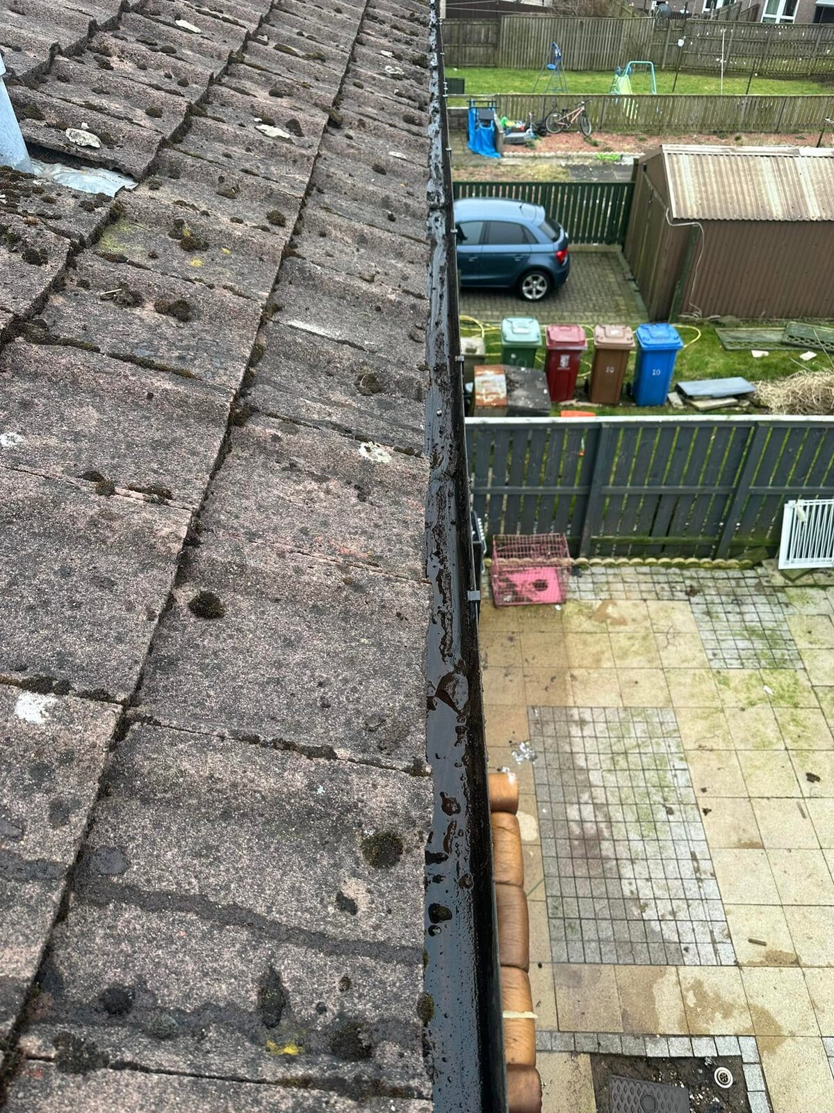 Gutter cleared and rinsed along concrete roof tiles