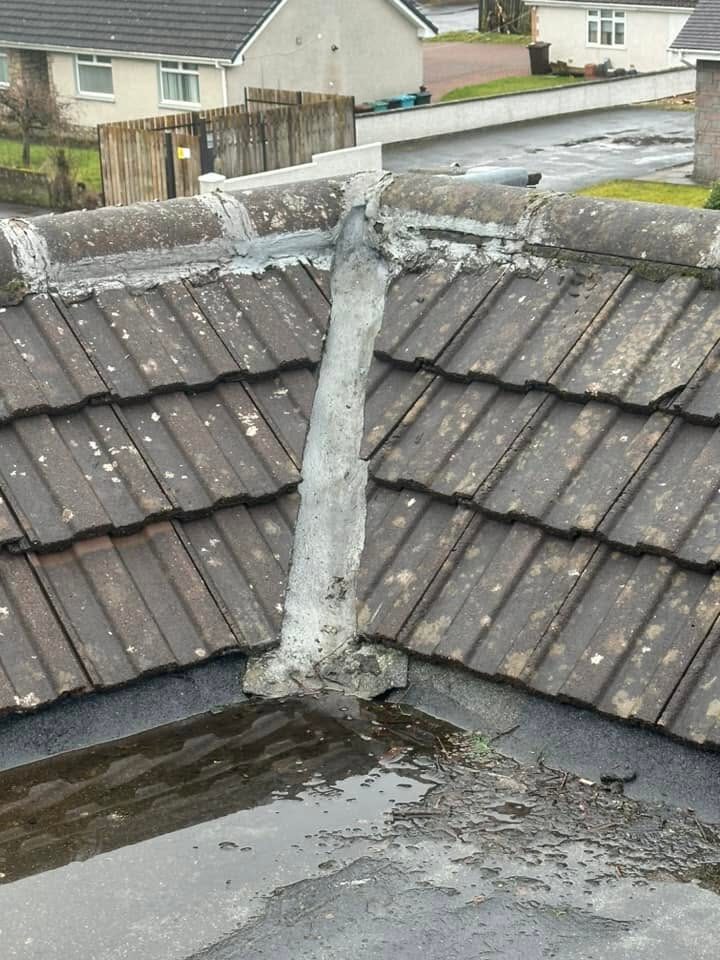 Old mortar-filled valley between two tiled roof slopes